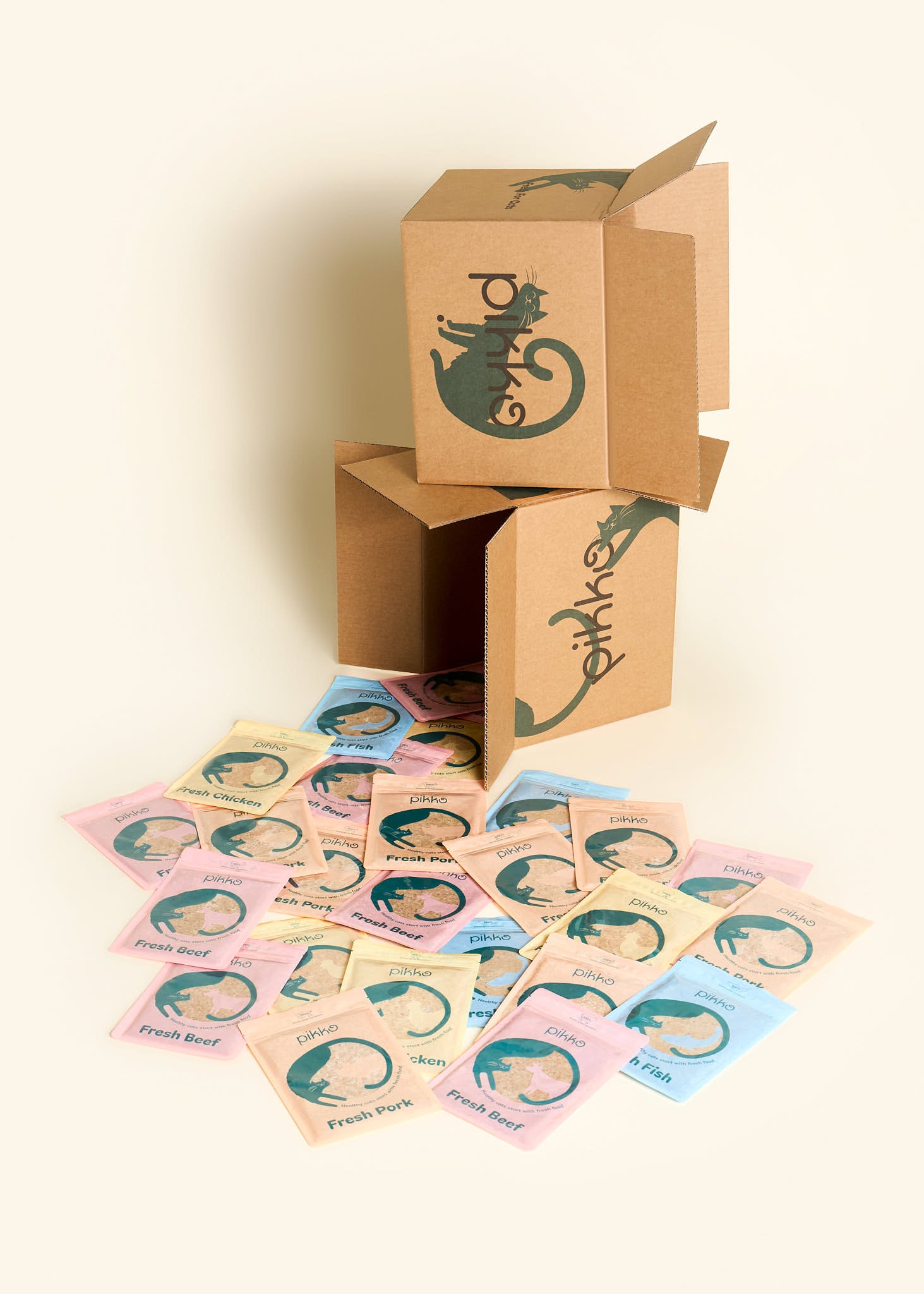 Two stacked Pikko delivery boxes with 28 pouches of fresh, human-grade cat food spilling out, featuring beef, chicken, pork, and fish recipes.